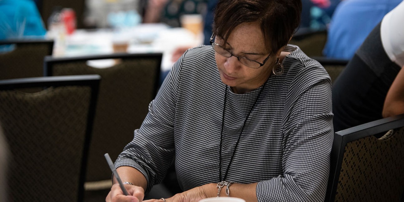 Woman sitting at table writing