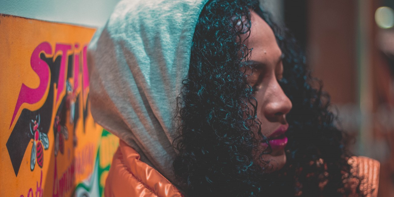 woman wearing hood standing near wall