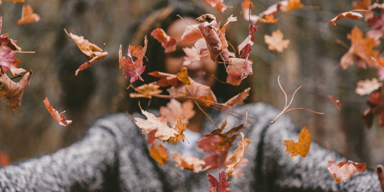 Person throwing leaves in the air