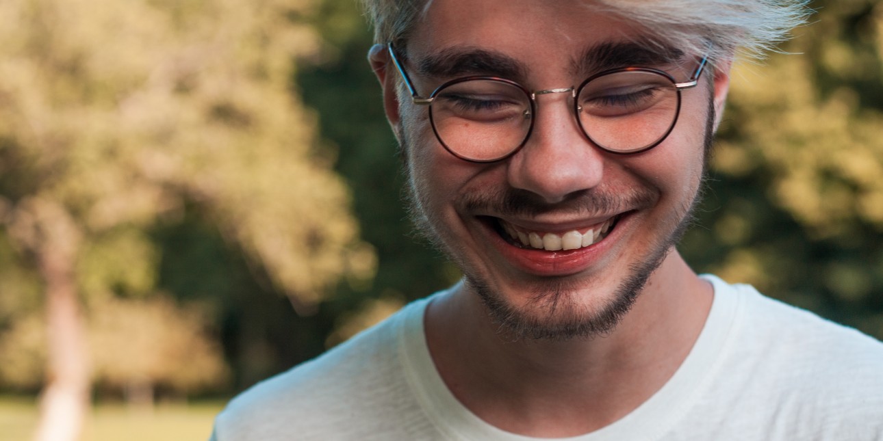 young adult in glasses smiling