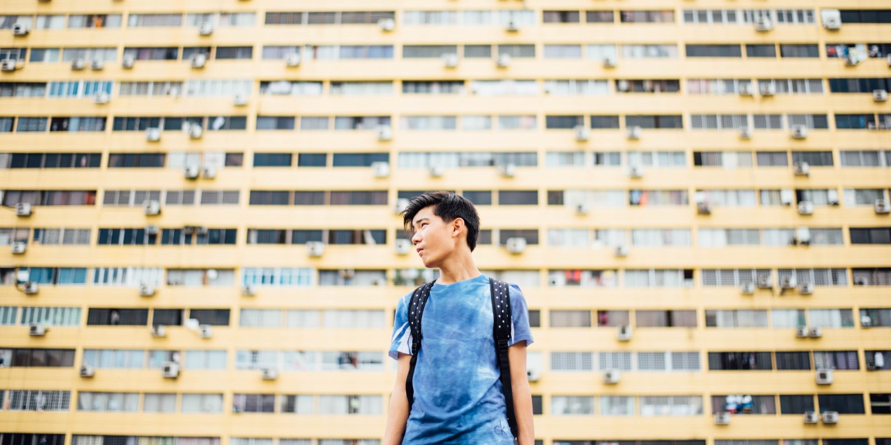 young person in front of apartment building