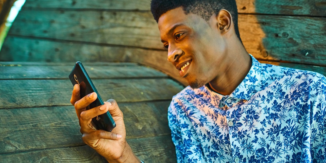 young black man looking at a phone