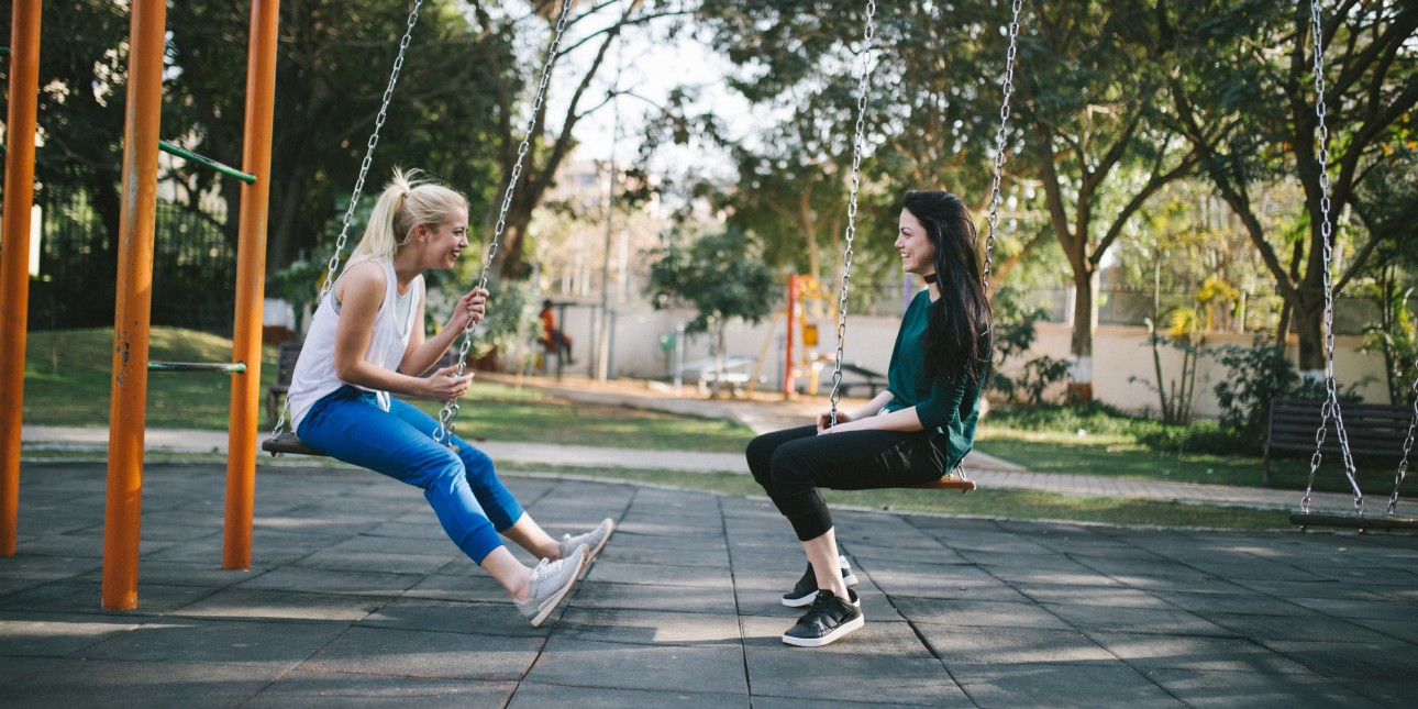 two young people on playground swings