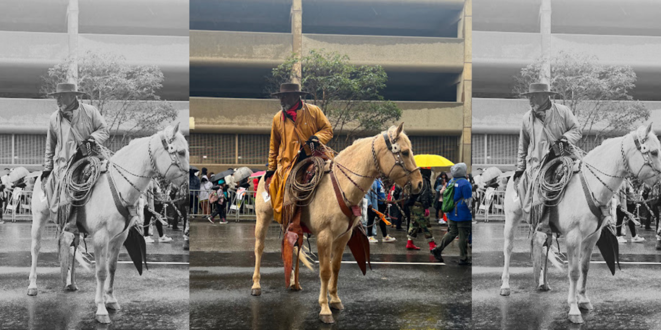 A Black cowboy sitting atop a beige horse looking behind him, while the horse prepares to walk forward. Picture taken during the annual Black Joy Parade.