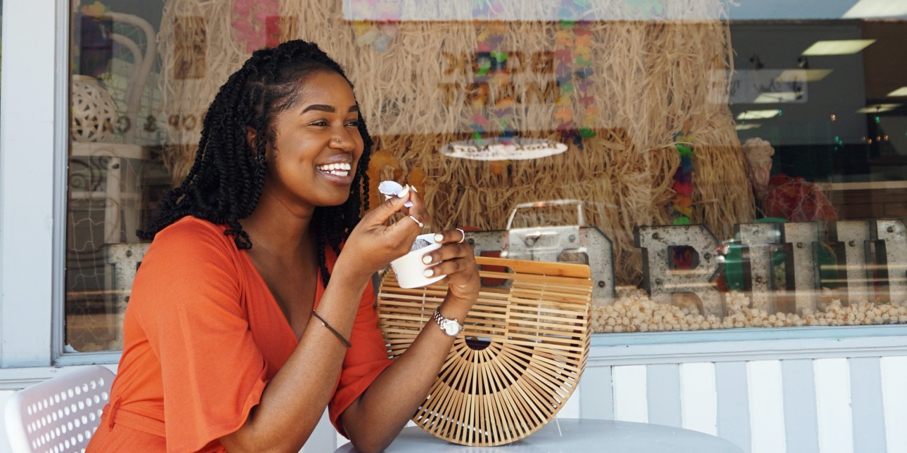 Woman Smiling and Eating Outside the Pop Porium Shop