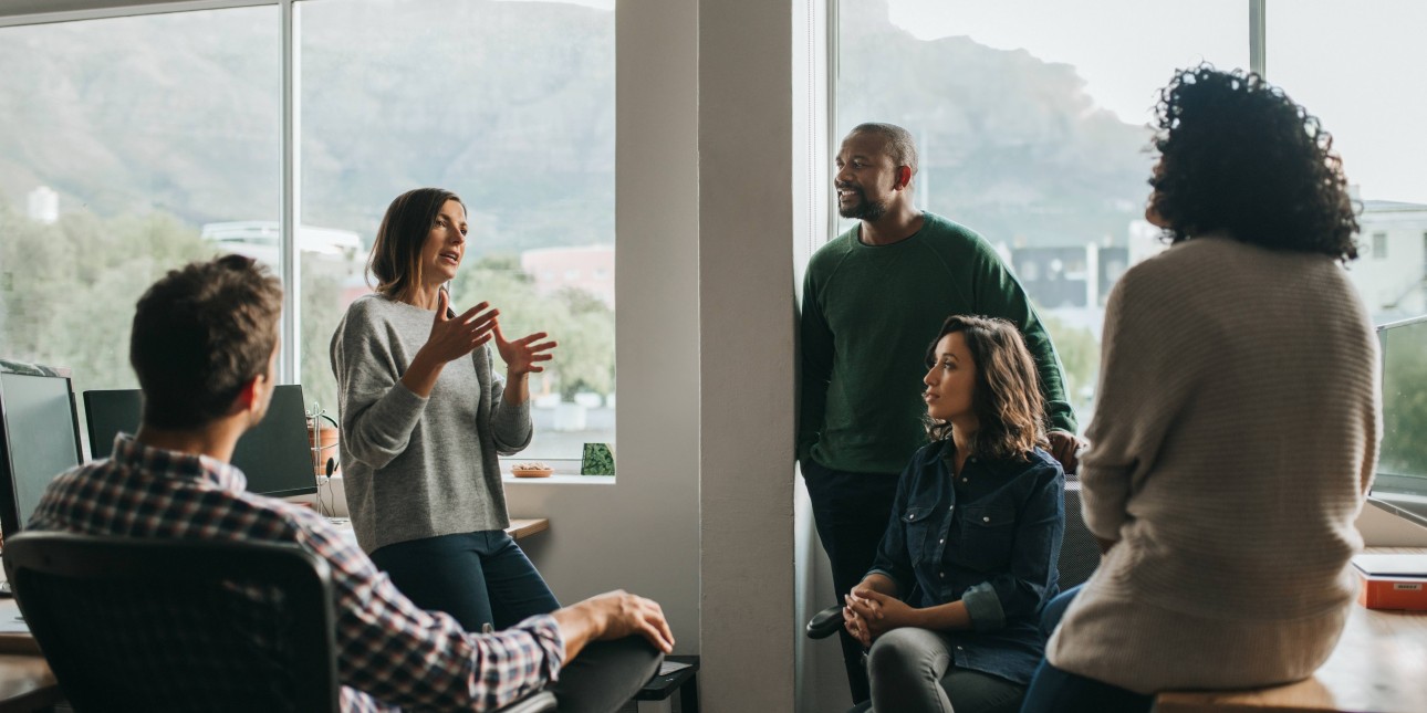 5 team members in an office collaborating 