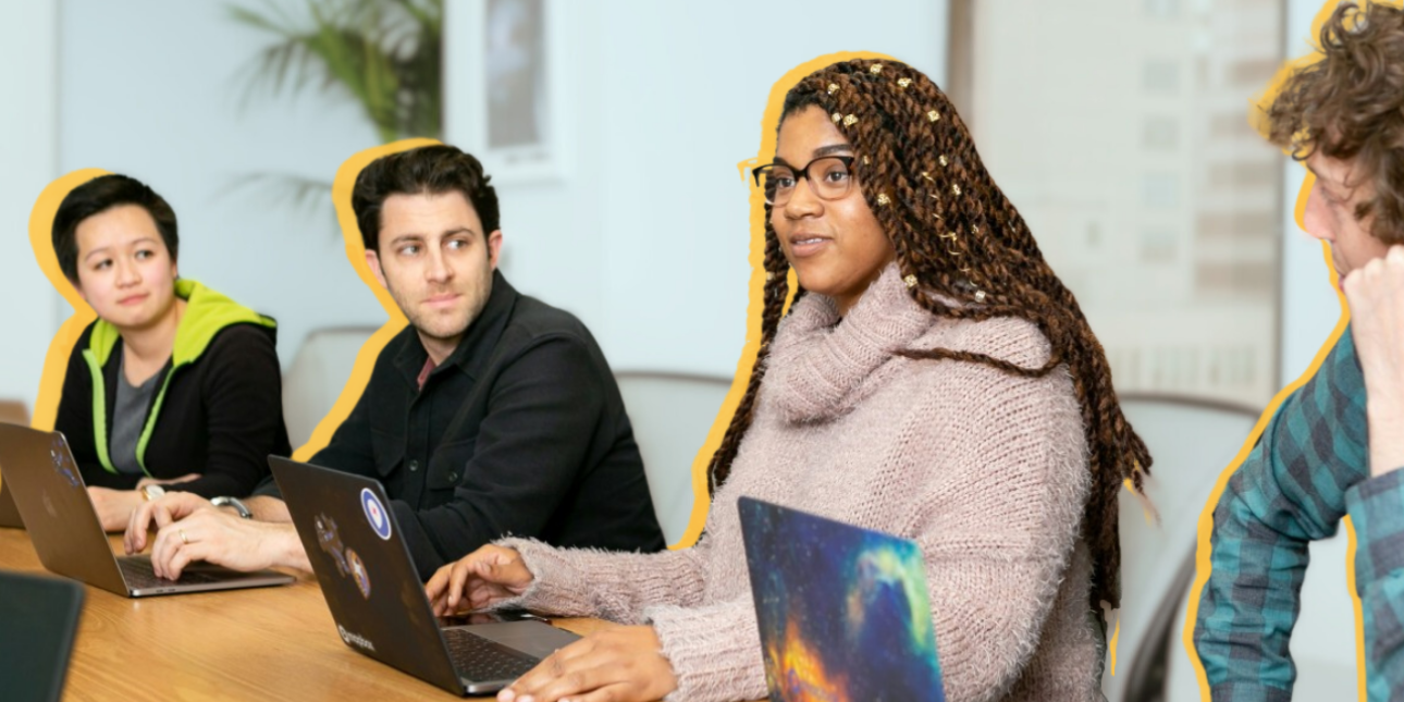 People sitting at a table with laptops