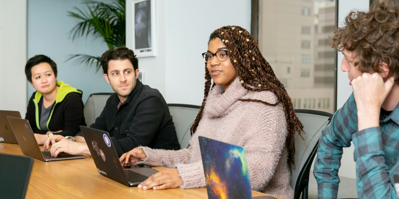 People sitting at a table with laptops