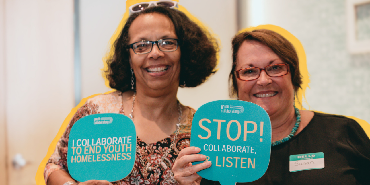 two women smiling and holding bubble cards about collaboration