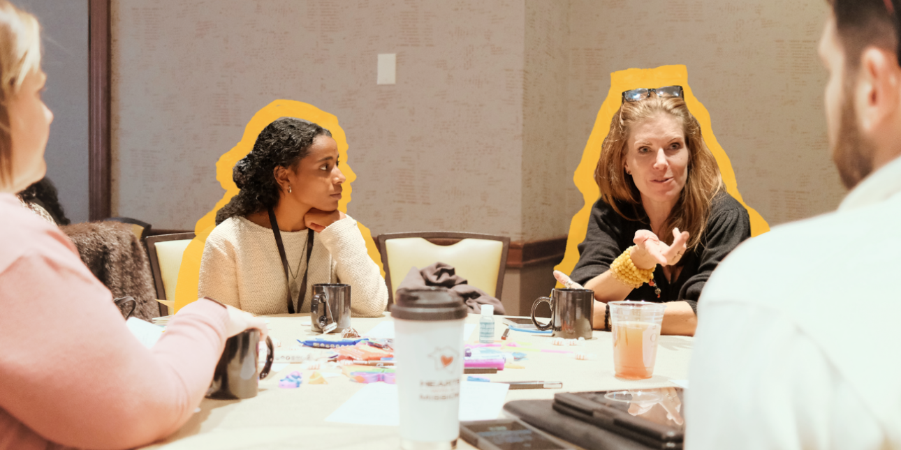 Four people engaged in discussion sitting at a table