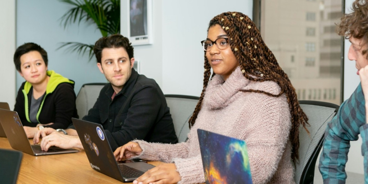 People sitting at a table with laptops
