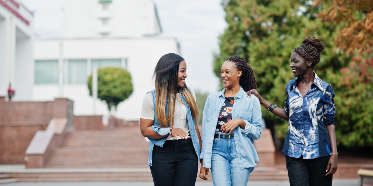 Three Black women walking and talking together.