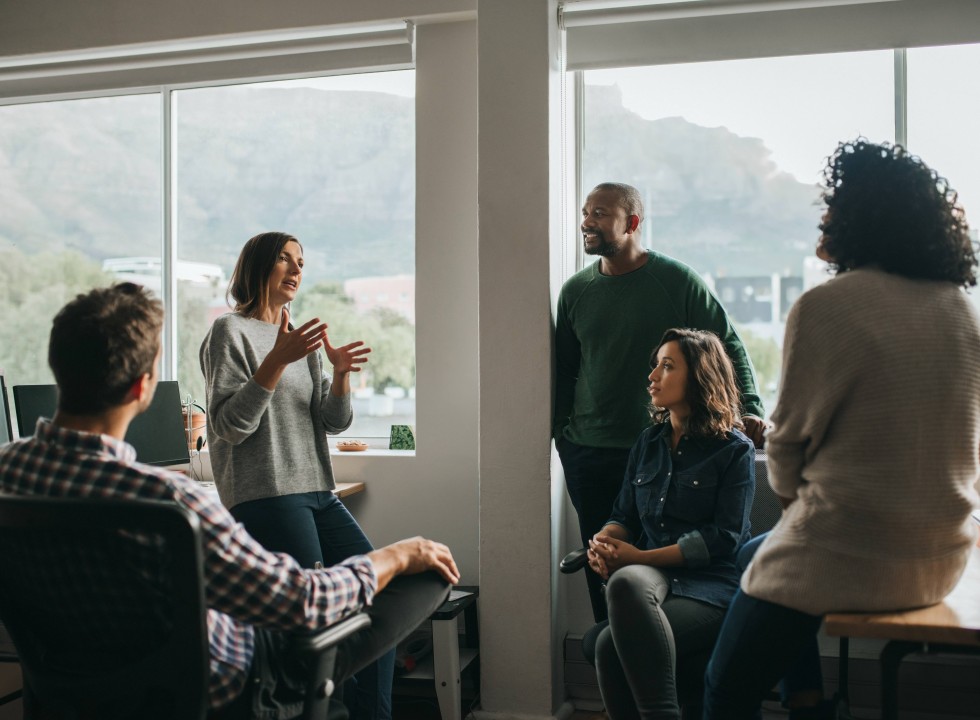 5 coworkers talking in an office