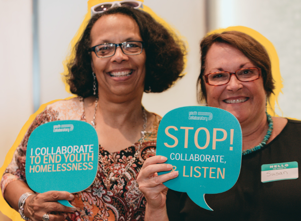 two women smiling and holding bubble cards about collaboration