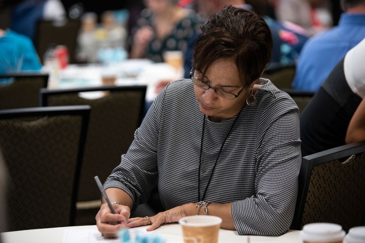 Woman sitting at table writing