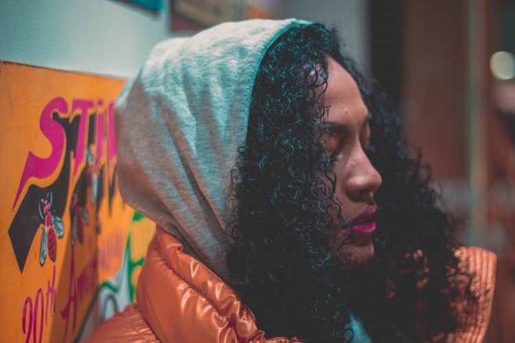 woman wearing hood standing near wall