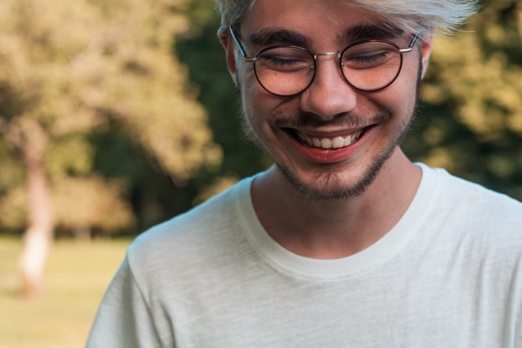 young adult in glasses smiling