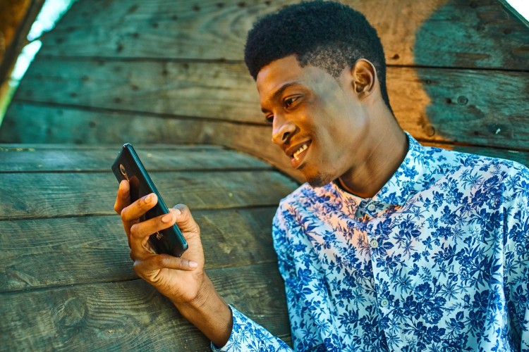 young black man looking at a phone