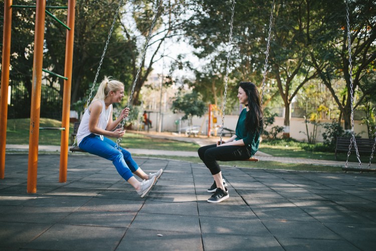 two young people on playground swings