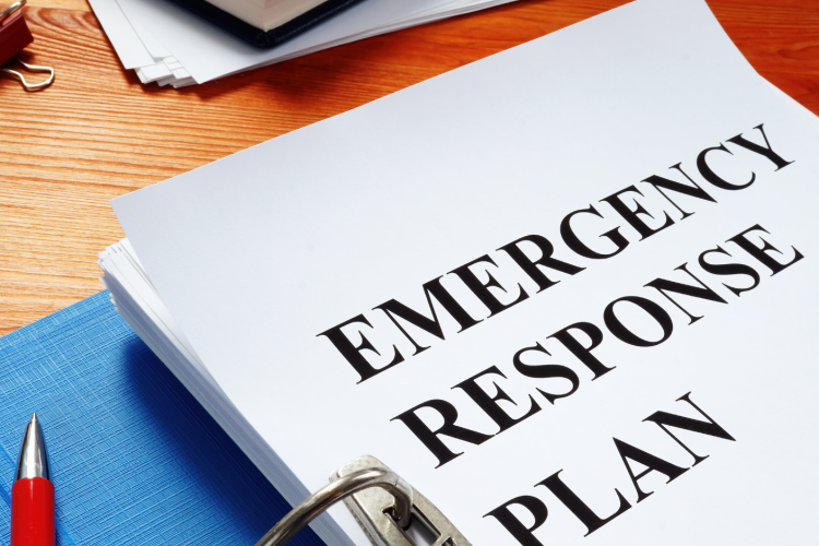 binder on desktop with title page reading "Emergency Response Plan"