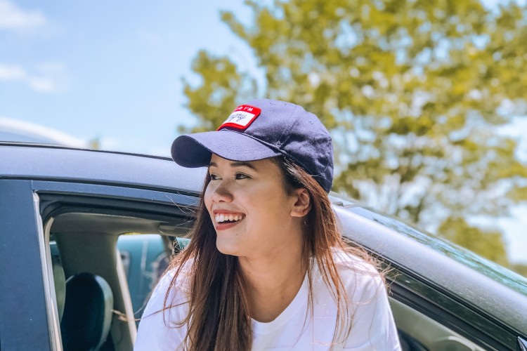 Happy young woman in car in city