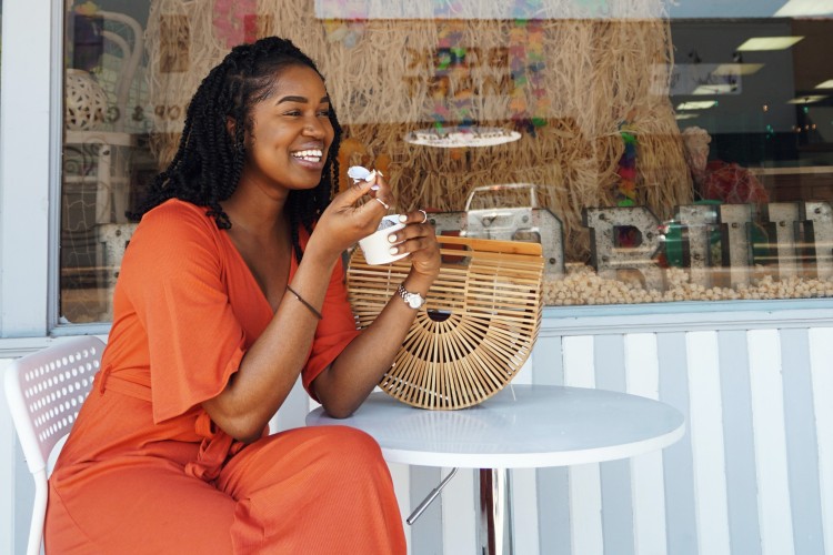 Woman Smiling and Eating Outside the Pop Porium Shop