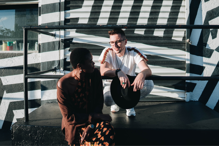 two young people sitting and conversing