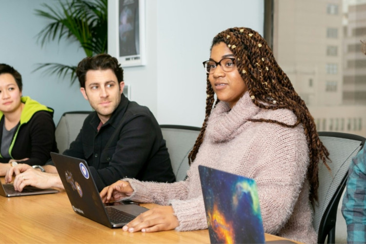 People sitting at a table with laptops